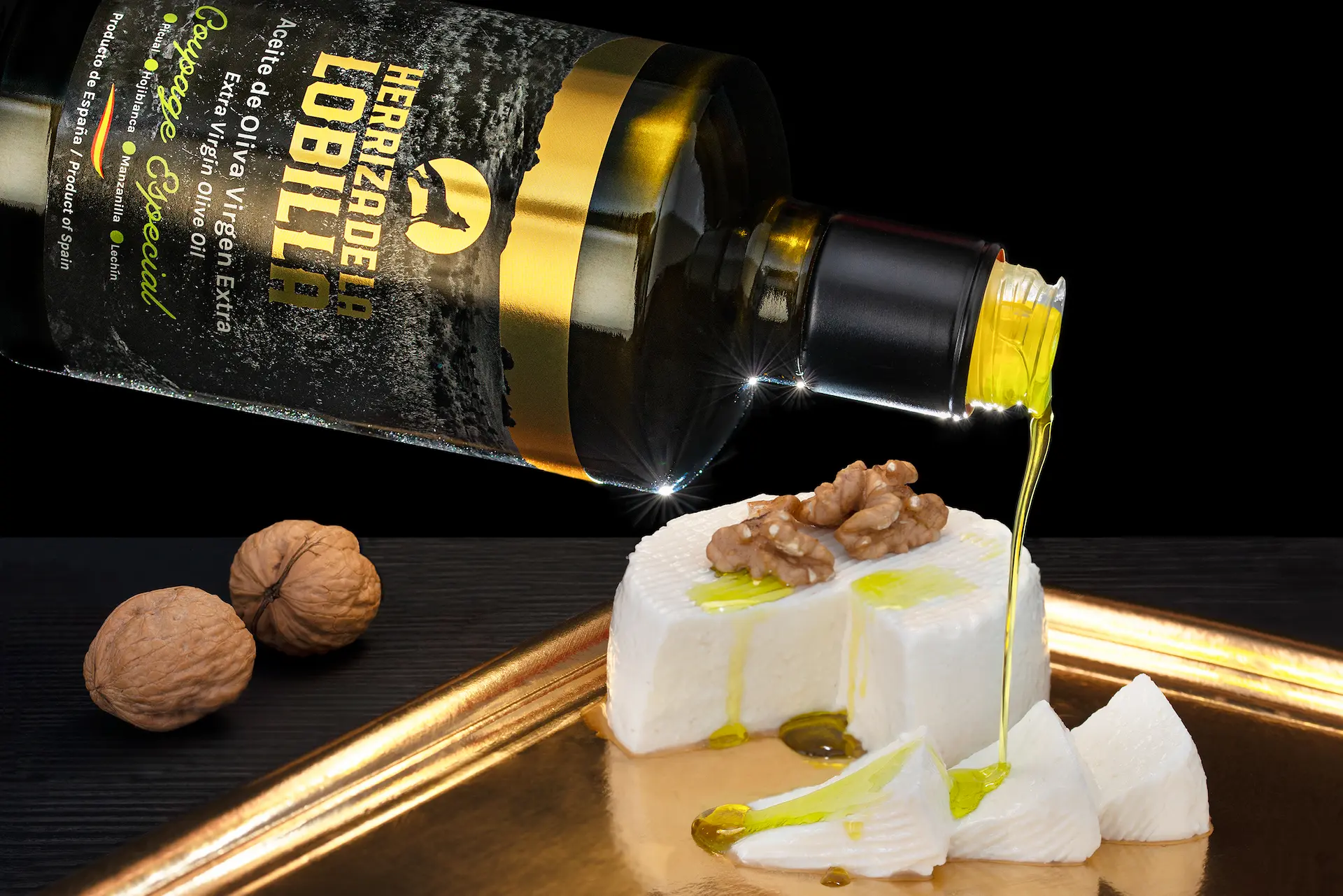 Garrafa de aceite oliva virgen extra Coupage Especial vertiendo el producto sobre queso fresco aderezado con nueces
