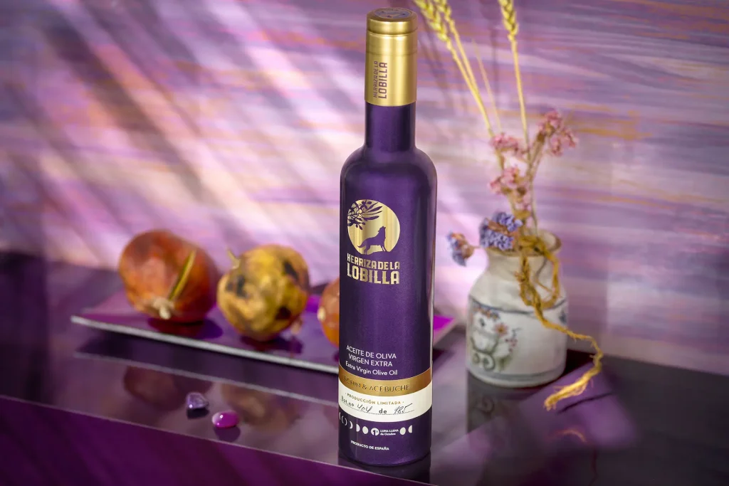 Botella de aceite de oliva virgen extra variedad lechín y acebuche sobre un fondo morado