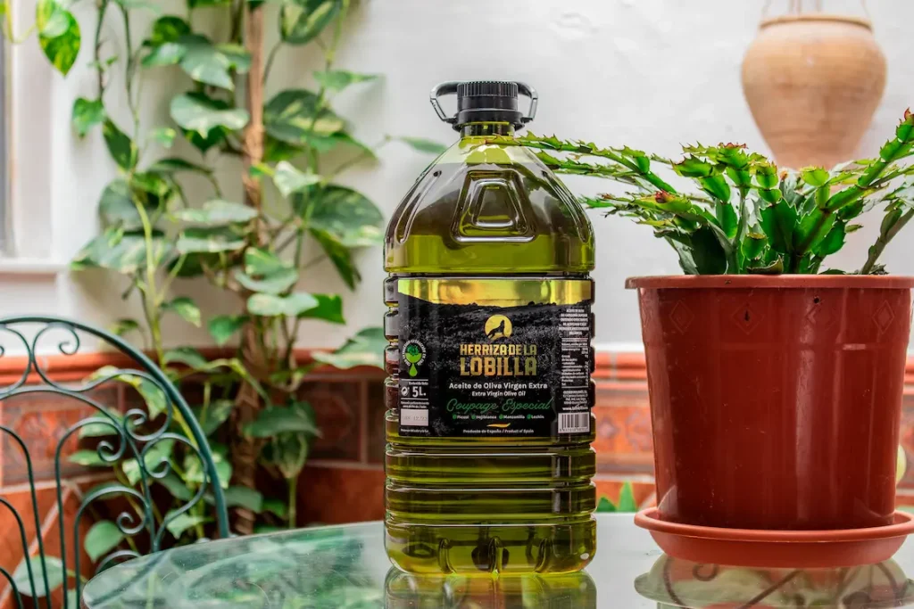 Garrafa de aceite oliva virgen extra Coupage Especial con fondo de típico patio andaluz